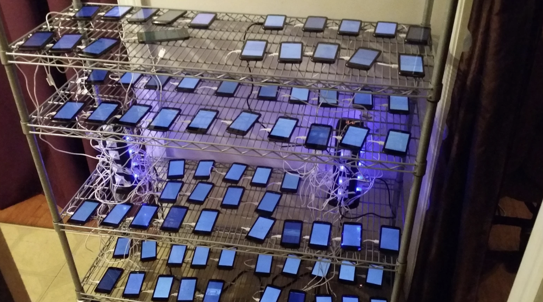 A massive click farm setup with tens of smartphones on racks, illustrating automated bot activity on social networks.